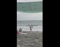 Woman bikini handstand leg split beach overcast
