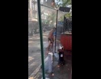 Man baths on street from fire hydrant