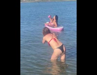 Woman lay on paddle board drink hold pink bottle