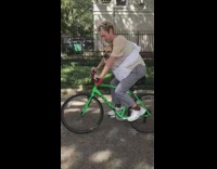 Guy rides bike with dog in swaddle