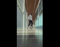 Guy dances empty hallway big windows