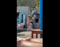 Woman in bikini adjusts phone for video