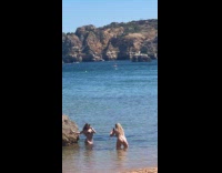 Collab IITW - Woman bikini sunglasses poses beside beach rock