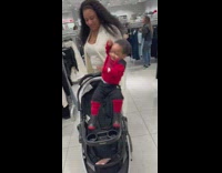 Woman picks up little kid puts in stroller 
