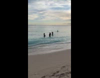 Woman in bikini dance video at beach