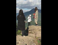 Woman long dress small dog big rock 