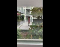 Red shirt girl dances fast apartment courtyard 