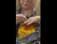 Woman with glasses sitting on subway train playing with pet rat
