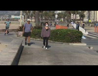 Girl carries surfboard and boogie board beach  