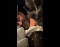 Woman cuddling with man in bed and dog