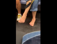 Man sits barefoot during train commute