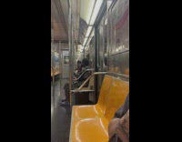 Guy sitting down smoking marijuana joint on subway train 
