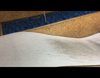 Boy does backflip on razor, lands but then falls onto wall, indoor skatepark