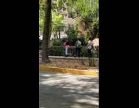 Woman pink jacket dance video shoot sidewalk