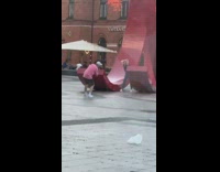 Black shirt girl poses large red sculpture 
