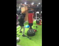 Guy punches red reebok punching bag gym