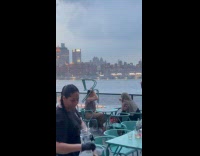 Collab WINY - Woman using chair to cover head from rain 