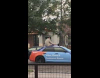 man sits on top of blue colorful car