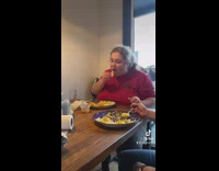 Family eating dinner girl serves herself more food 