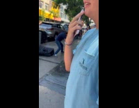 Store owner and homeless man fighting on sidewalk