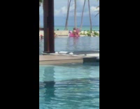 Woman sit pink horse floatie pool trees