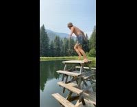 Guy jumps into pond from stacked tables 