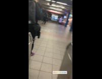 Girl wears orange fox tail walking in subway station