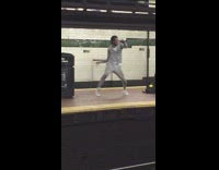 a woman in grey sweatsuit dances on subway station