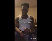 Guy white shirt sitting smirks at camera