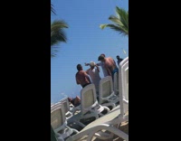 Man holds up cup of coffee in the sky while woman takes picture