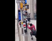 Guy hangs light body parallel to sidewalk