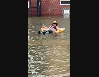 Woman with floaties on flood drinks beer