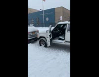 Parked jeep with door left open in snowstorm covered in snow