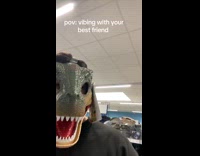 Best friends goofing around wearing dinosaur mask