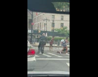 Guy in a costume and bowl cut dances in street