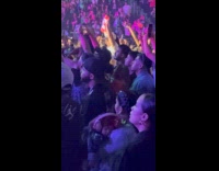 Woman hold baby with headphones at concert