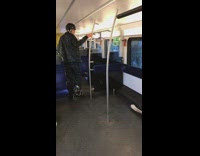 Man dressed in snow gear puts skis on subway train floor