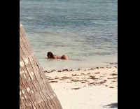Tan Lady Poses Laying in Beach Water 