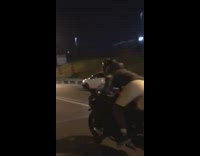 Motorcycle drives past car freeway night time
