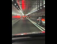Man on sunroof of car in tunnel