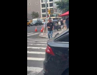 Bald man with mask and cape dancing on street 