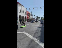 Woman wetsuit lie down green surfboard middle of street