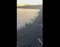 Black shorts girl squats friend sits rock 