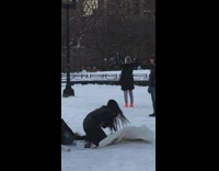 Girl kneeling on tarp over snow dances 