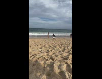 Woman in pink bikini walks and poses at the beach