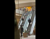 Man brown shirt pose on downward escalator