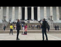 Bald guy black suit memorial grey hat
