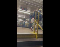 Guy walking up stairs holding legs of half mannequin through subway station