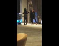 Woman poses and flexes butt in front of the escalator