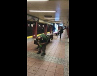 Man holds and drinks a bottle of 2 liter Mountain Dew and walks around subway station